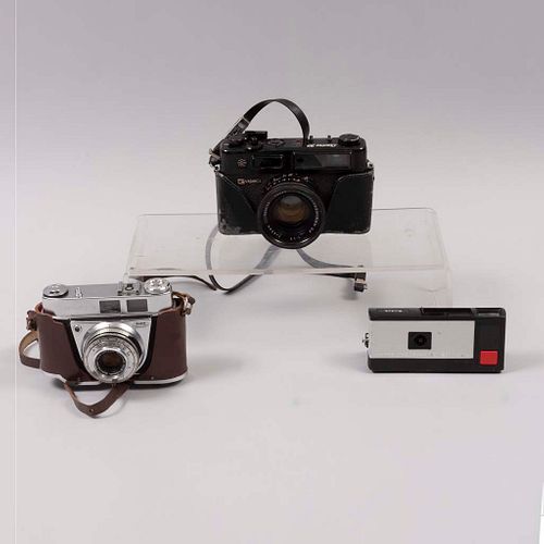 Lote de 3 cámaras fotográficas. Siglo XX. Elaboradas en metal, baquelita y material sintético. Marca Yashica y Kodak.
