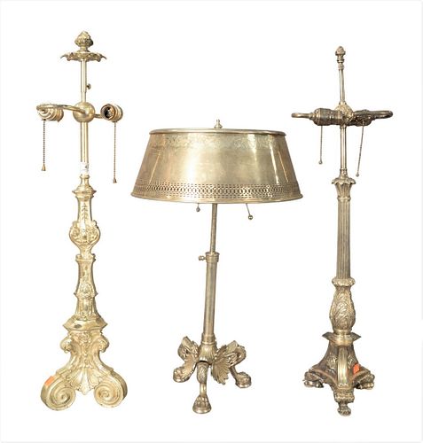 Group of Three Silvered Table Lamps, to include two candlestick form raised on paw feet, along with an adjustable bouillotte lamp; height 31 inches.