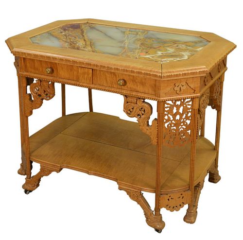Aesthetic Movement Figured Maple Victorian Table, having inset onyx top and one drawer, with carved supports and carved legs, feet with double castors