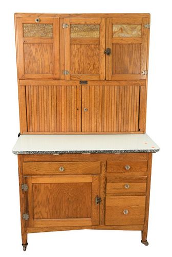 Oak Hoosier Cabinet by Sellers, having tambour doors, in two parts, height 70 inches, width 41 inches, depth 28 inches.