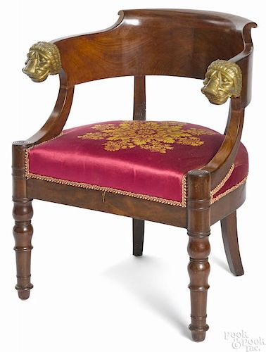 French Empire mahogany low back armchair with ormolu lion's head handholds.