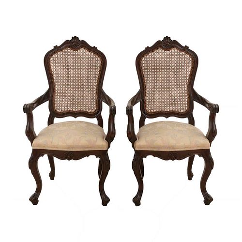 Par de sillones. SXX. Talla en madera. Con respaldos cerrados de bejuco y asientos en tapicería color beige.