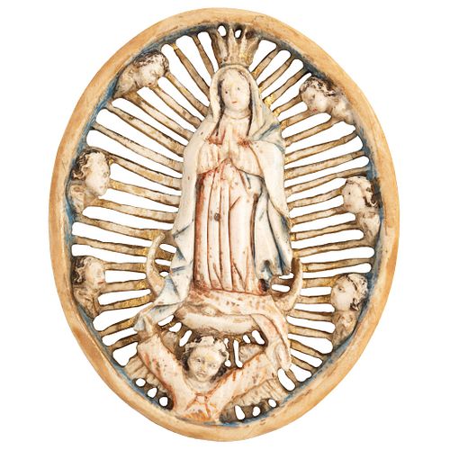 VIRGIN OF GUADALUPE MEXICO, Ca. 1900. Made of carved and inked ivory. Conservation details. 2.9 x 2.7" (7.5 x 7 cm)