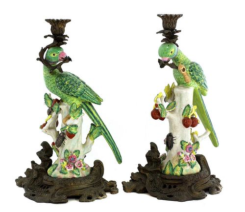 A pair of gilt brass mounted pottery parrot candlesticks,