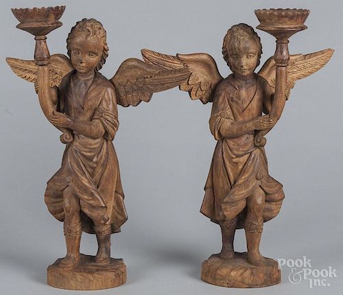 Pair of carved walnut figural pricket sticks, early 20th c., 16'' h.