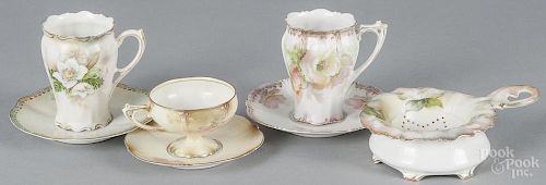 Four pieces of R. S. Prussia porcelain, ca. 1900, to include a tea strainer and three cups