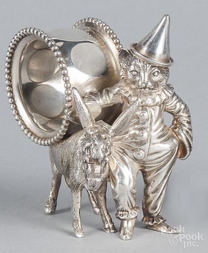 Silver-plate figural napkin ring, early 20th c., of a cat in a clown suit leading a donkey, 4'' h.