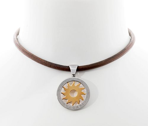 BVLGARI.
Tondo Sun pendant.
In 18kt yellow gold and stainless steel. Brown leather cord with carabiner clasp.