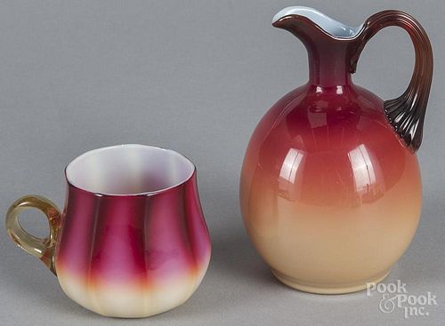 Two pieces of Amberina glass, early 20th c., to include a creamer, 5 1/2'' h., and a cup.