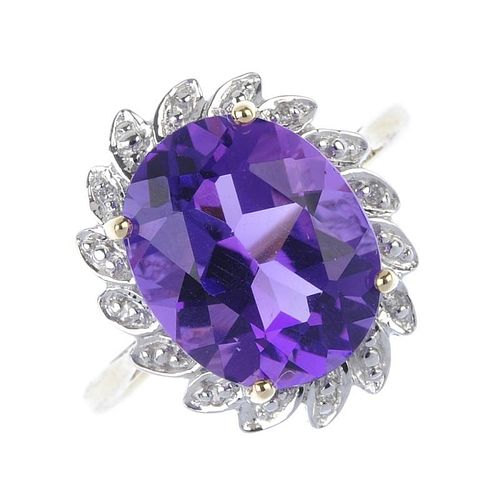A 9ct gold amethyst and diamond floral cluster ring. The oval-shape amethyst, within a single-cut di