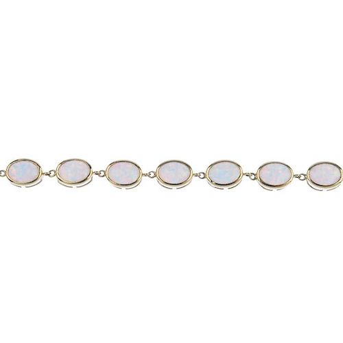 A synthetic opal line bracelet. Designed as a series of oval synthetic opal cabochons, each within a
