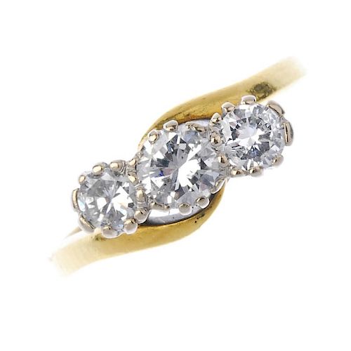 An 18ct gold diamond three-stone ring. The slightly graduated brilliant-cut diamond diagonal line, t