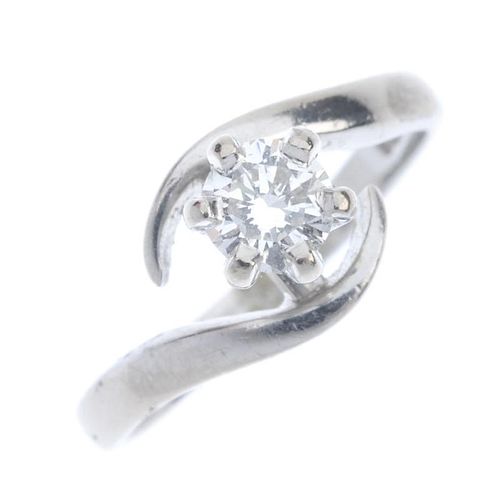 An 18ct gold diamond single-stone ring. The brilliant-cut diamond, to the asymmetric curved shoulder