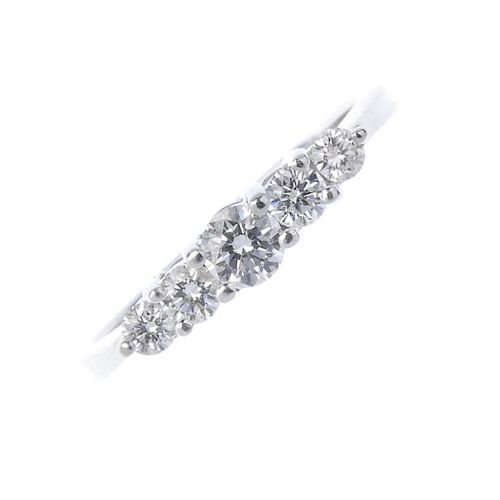 A diamond five-stone ring. The graduated brilliant-cut diamond stepped line, to the tapered shoulder