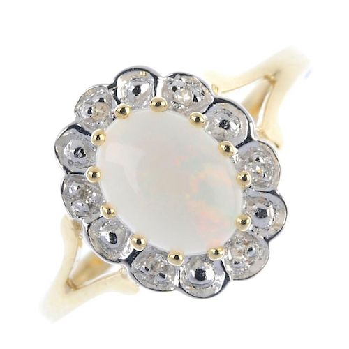 A 9ct gold opal and diamond cluster ring. The oval opal cabochon, within an illusion-set diamond sca