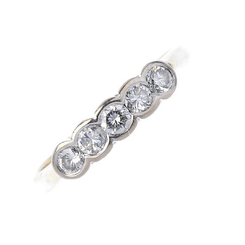 An 18ct gold diamond five-stone ring. The brilliant-cut diamond line, within a shared collet surroun