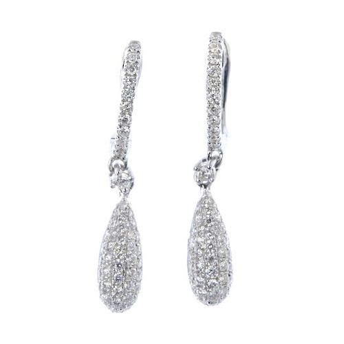 * A pair of diamond ear pendants. Each designed as a pave-set brilliant-cut diamond tapered drop, to