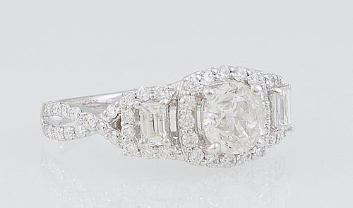 Lady's 18K White Gold Dinner Ring, with a central .54 ct. round diamond atop a border of round diamonds flanked by lugs with central baguette diamonds
