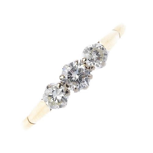 An 18ct gold diamond three-stone ring. The graduated brilliant-cut diamond line, to the plain band.