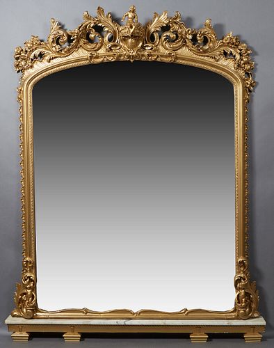 American Gilt and Gesso Rococo Revival Figural Overmantel Mirror, 19th c., the arched top with an elaborate central seated putto and scrolled leaf and