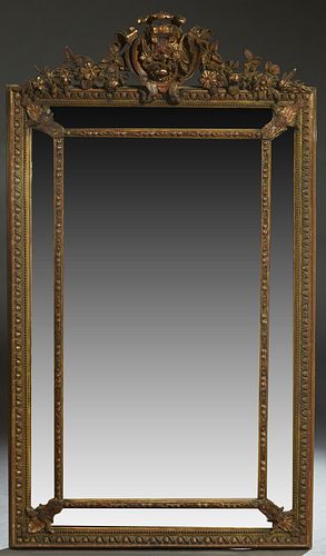 French Louis XV Style Gilt and Gesso Beech Overmantel Mirror, 19th c. , with an arched pierced floral crest over a cushion mirror with a relief frame 