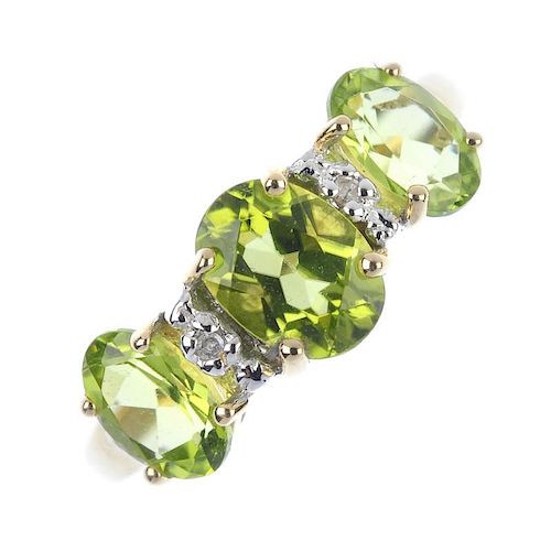 A 9ct gold peridot and diamond ring. The oval-shape period, within single-cut diamond spacers. Hallm
