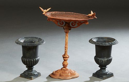 Three Cast Iron Garden Pieces, 20th/21st c., consisting of a pair of small campana form jardinieres, the everted relief rim over a lobed side to a squ