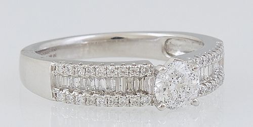 Lady's Platinum Dinner Ring, with a central .4 ct. round diamond flanked by shoulders of the band with a central row of diamond baguettes, within bord