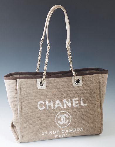Chanel Front Logo Deauville Tote Shoulder Bag, in beige canvas and leather  accents with silver hardware, the magnetic snap closure opening to a dark b  sold at auction on 18th July