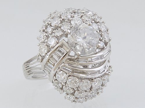 Lady's Platinum Dinner Ring, with a central round 1.51 ct. diamond on a sloping top mounted with round and baguette diamonds, on a split shouldered ba