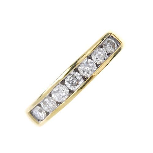 An 18ct gold diamond half-circle eternity ring. The brilliant-cut diamond line, to the tapered half-