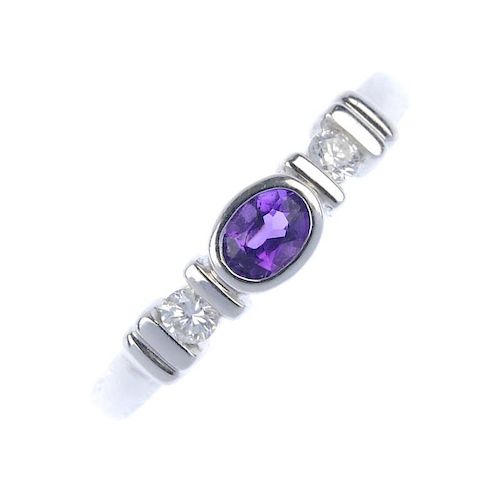 An 18ct gold amethyst and diamond ring. The oval-shape amethyst, with brilliant-cut diamond sides an