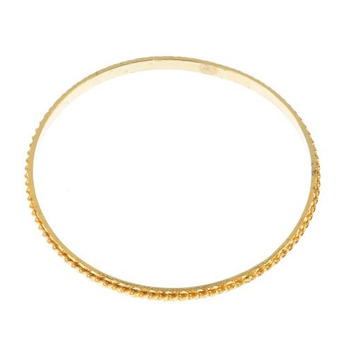 A 22ct gold bangle. Of spiral and bright-cut design. Hallmarks for London, 2007. Inner diameter 6.1c