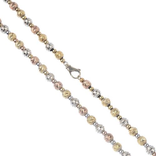 A 9ct gold necklace. Of tri-colour design, the bright-cut beads, with polished bead spacers, to the