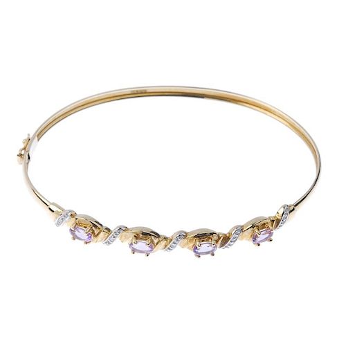 A 9ct gold diamond and amethyst bangle. The front designed as a series of oval-shape amethysts, with