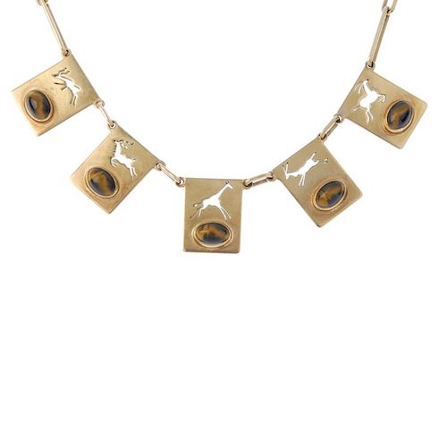 A tiger's-eye novelty necklace. Of African design, the front designed as a series of rectangular-sha