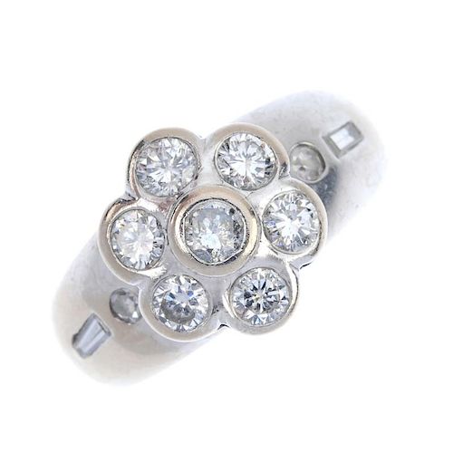 An 18ct gold diamond floral cluster ring. The brilliant-cut diamond floral cluster, to the plain ban