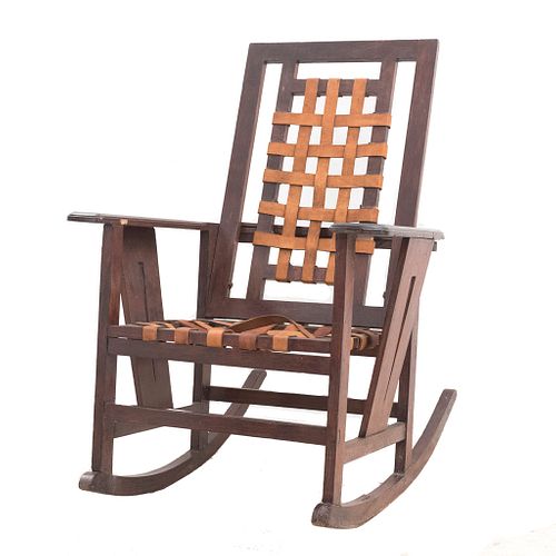 Mecedora. Siglo XX. Elaborada en madera. Con asiento y respaldo de piel. Soportes lisos y chambrana de caja.