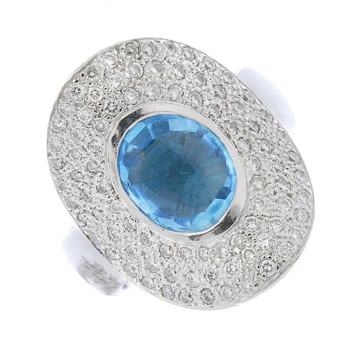 A topaz and diamond dress ring. The oval-shape blue topaz collet, within a pave-set diamond curved s
