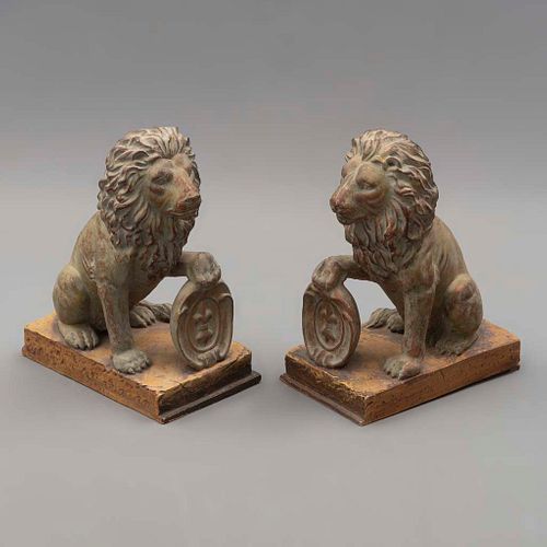 Par de sujetalibros. SXX. DiseÃ±o a manera de leones sosteniendo un blasÃ³n. Elaborados en resina. Acabado a manera de bronce patinado.