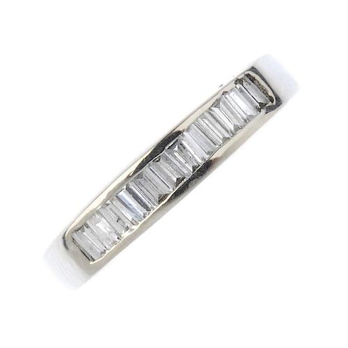 An 18ct gold diamond half-circle eternity ring. The baguette-cut diamond line, to the slightly taper