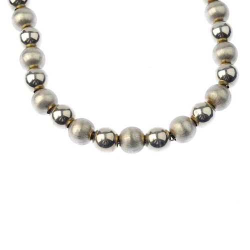 A 9ct gold bead necklace. Designed as a series of textured and polished gold beads. Hallmarks for 9c