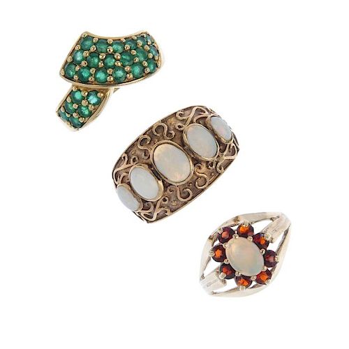 A selection of three gem-set dress rings. To include a 9ct gold emerald crossover ring, a 9ct gold g
