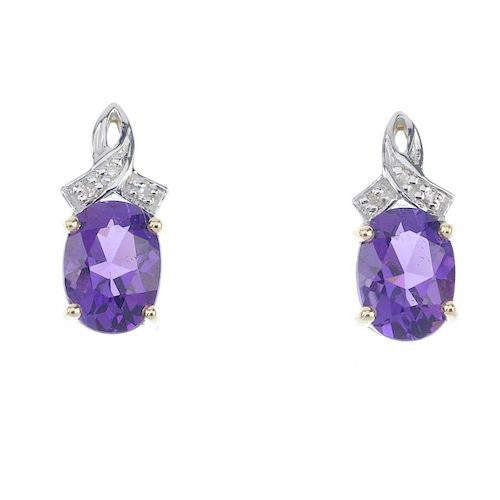 A pair of amethyst and diamond ear pendants. The oval-shaped amethyst suspended from a single-cut cr