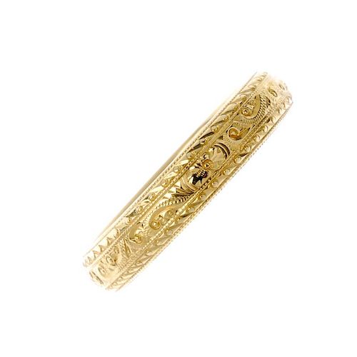 An 18ct gold band ring. Designed with engraved scroll and foliate detail. Hallmarks for Birmingham,
