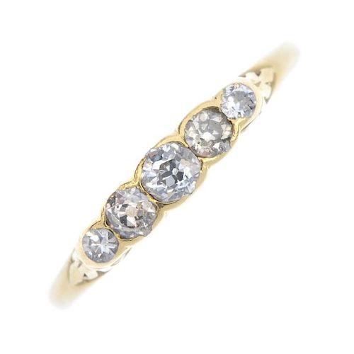 A 1920s 18ct gold diamond five-stone ring. The graduated old-cut diamonds, to the scrolling gallery