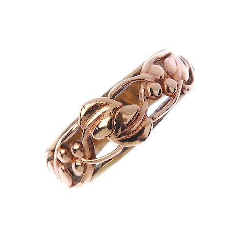 CLOGAU - a 9ct gold 'tree of life' ring. Of bi-colour design, the scrolling berry and foliate openwo