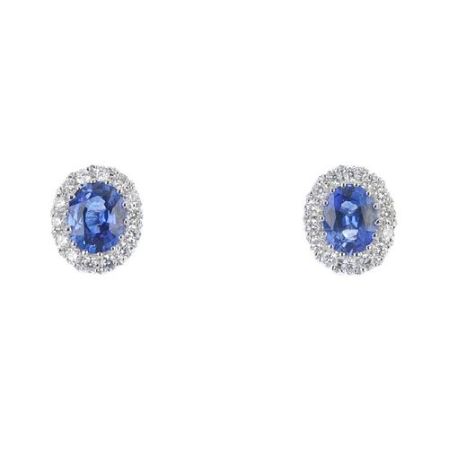 * A pair of sapphire and diamond cluster ear studs. Each designed as an oval-shape sapphire, within
