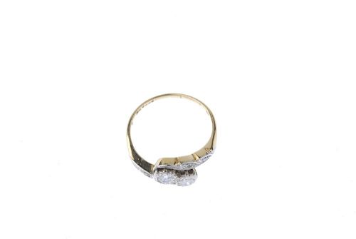 An early 20th century 18ct gold and platinum diamond two-stone ring. The old-cut diamond diagonal li