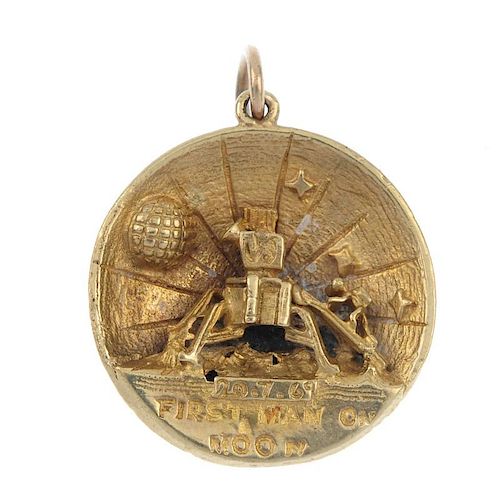 A novelty pendant. The front depicting the moon and earth, the reverse reading; First Man on the Moo
